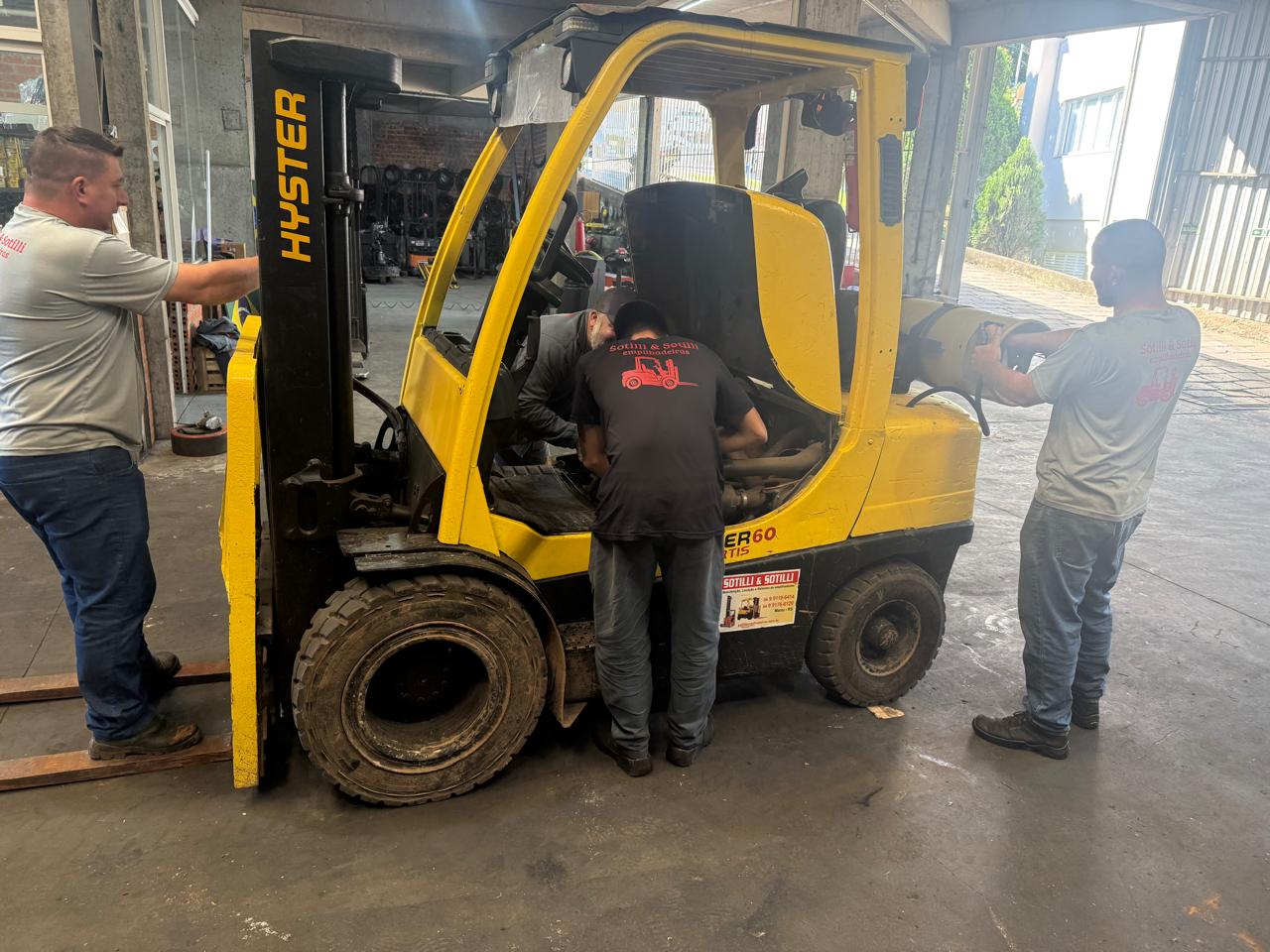 Equipe da Sotilli trabalhando na manutenção de uma empilhadeira na oficina