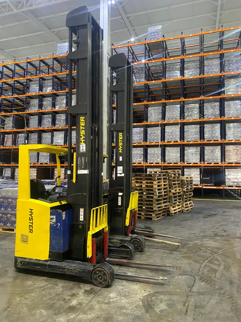 Empilhadeiras retráteis Hyster em frente a estruturas de armazenagem